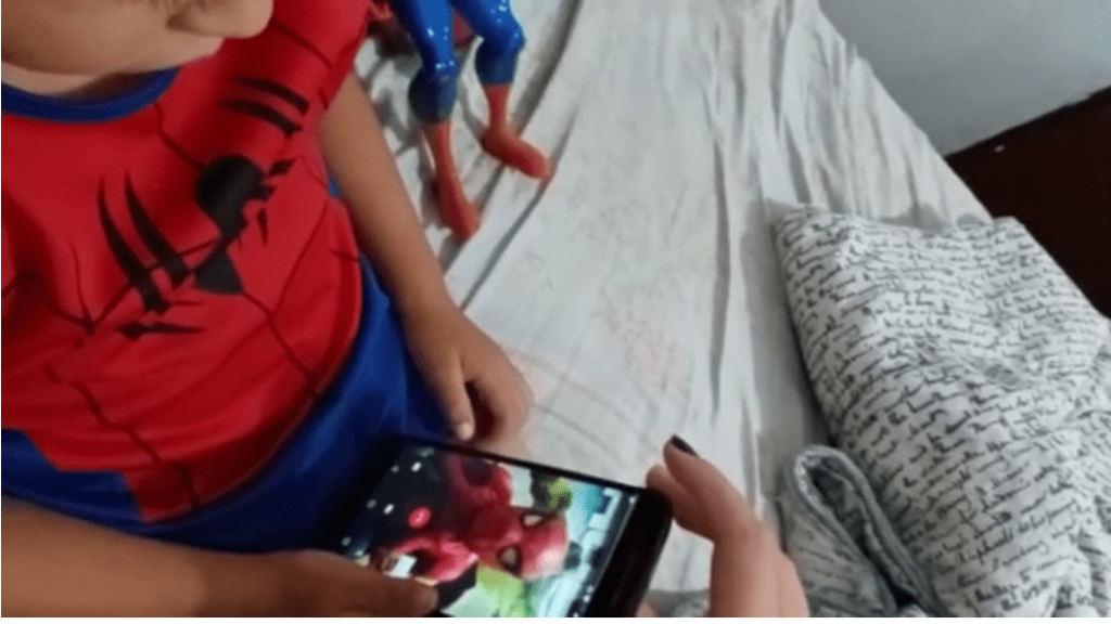 Vestido de super heróis, como o Homem- Aranha, ele usa o WhatsApp para aconselhar crianças a se cuidar na pandemia.