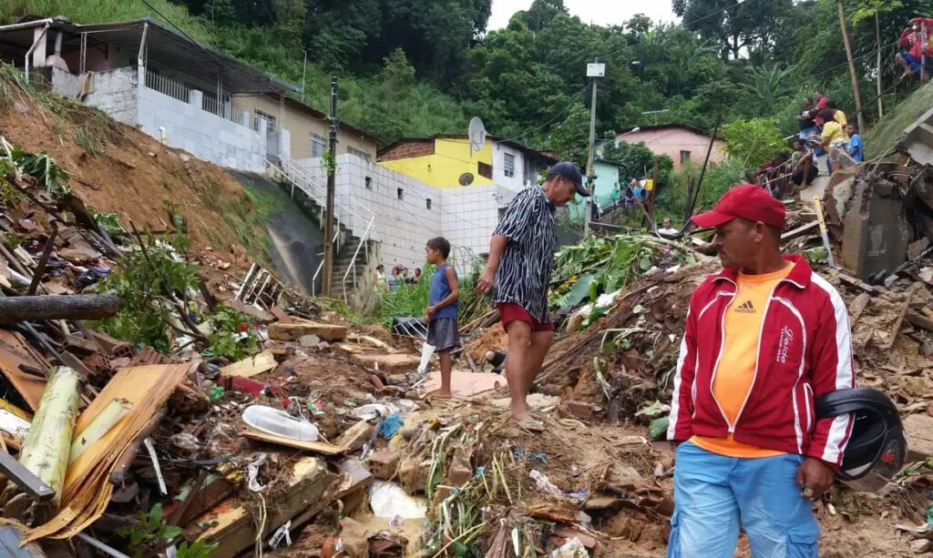 Na imagem homens retiram detritos de encosta que desabou após chuva intensa em Pernambuco.